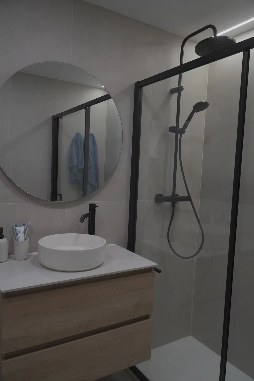 Ducha con mampara de perfil negro en un baño reformado y seguro para personas mayores en A Coruña